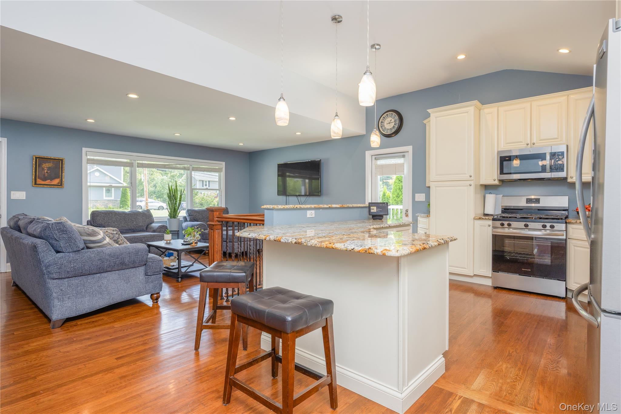 395 Ehrhardt Road Pearl River, NY 10965 - Photo 4 of 34 Open-concept living space featuring wood-finish flooring, recessed lighting, a kitchen island with stone countertop, and stainless steel appliances