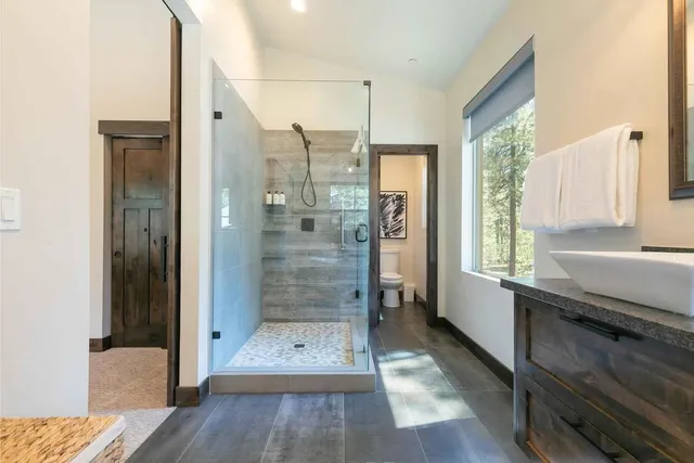a bathroom with a glass shower door and a window