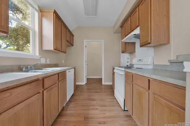 a kitchen with granite countertop white cabinets and sink