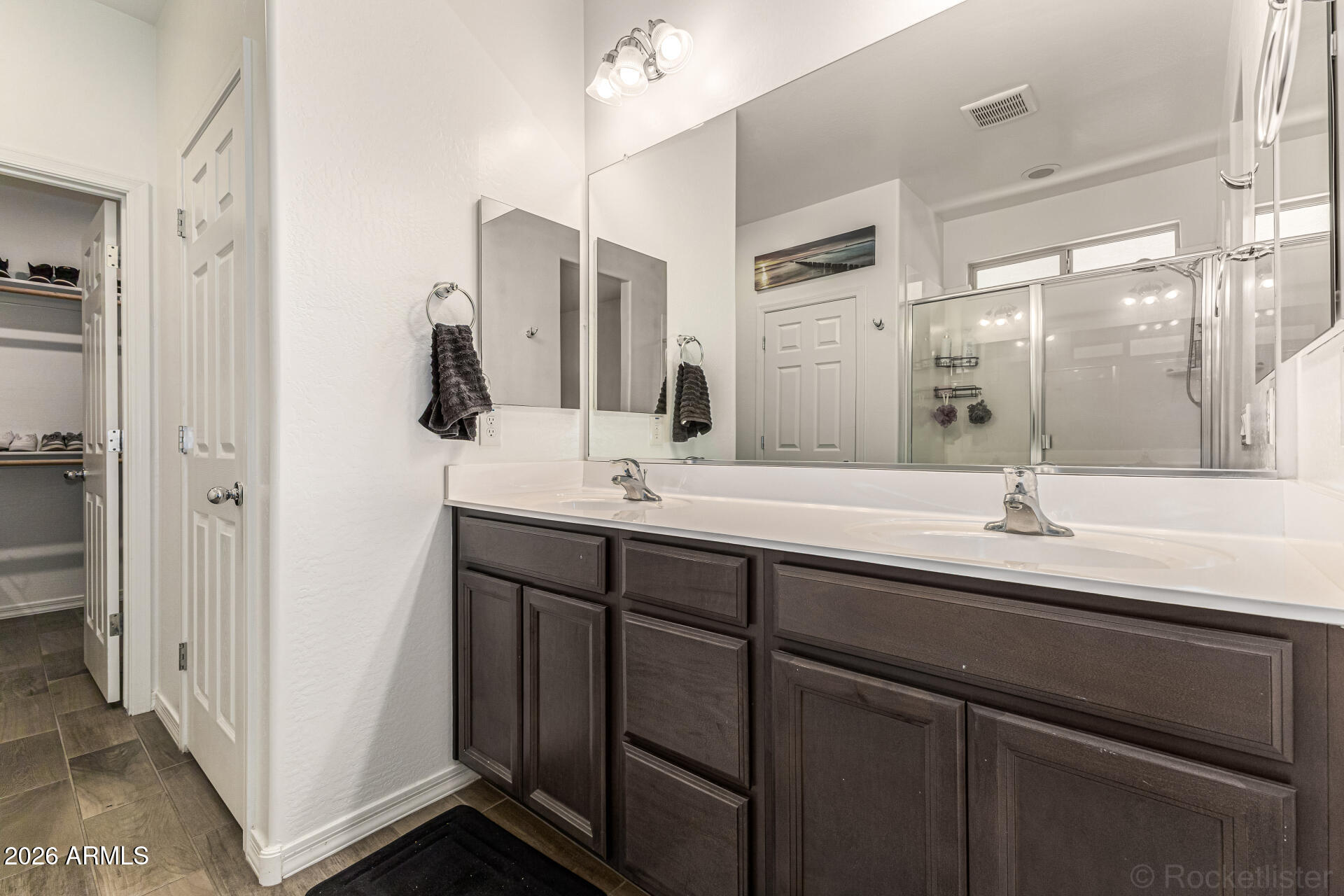 Undisclosed Address Avondale, AZ 85323 - Photo 16 of 32 a bathroom with a double vanity sink a mirror and shower