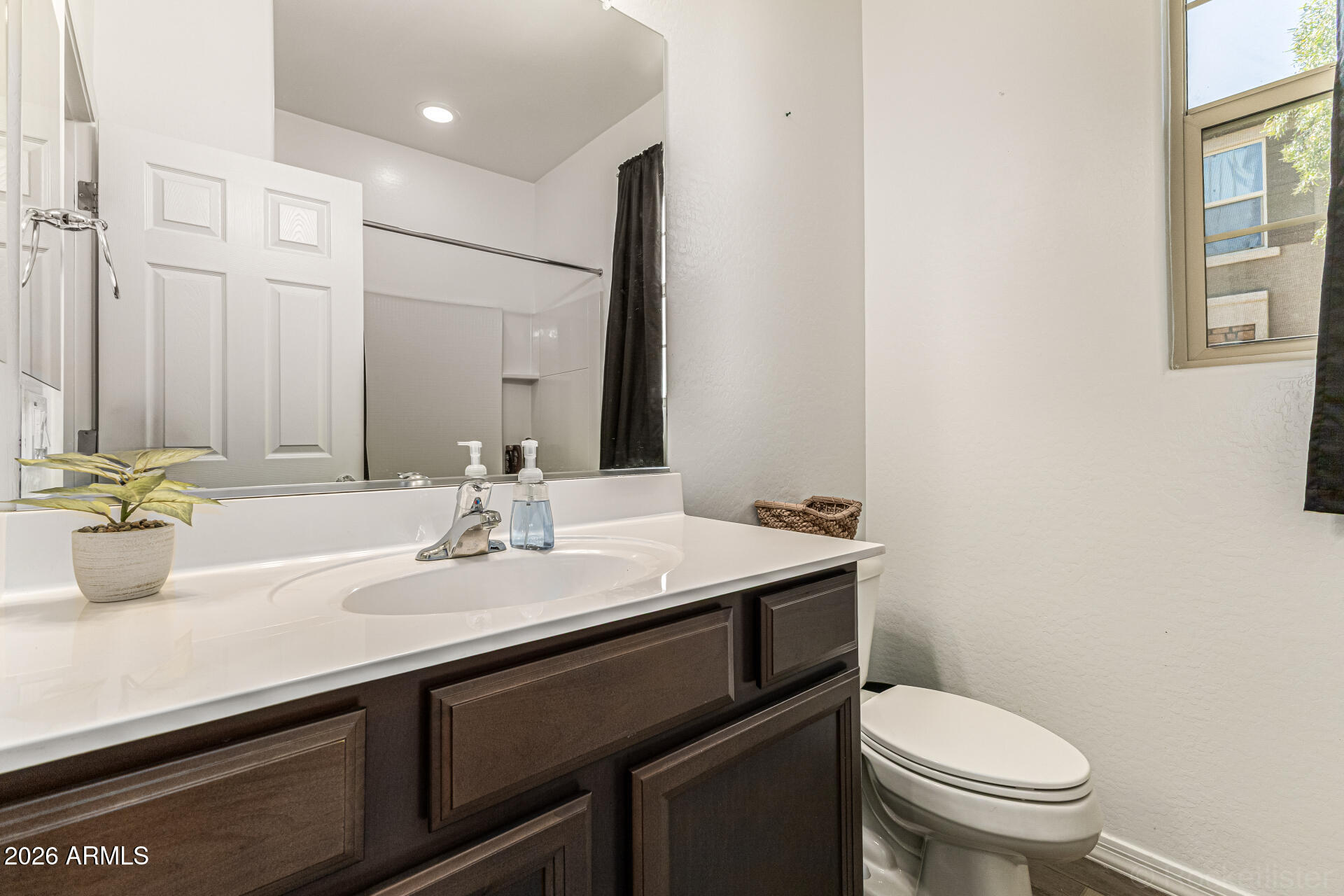 Undisclosed Address Avondale, AZ 85323 - Photo 23 of 32 a bathroom with a granite countertop toilet sink and mirror