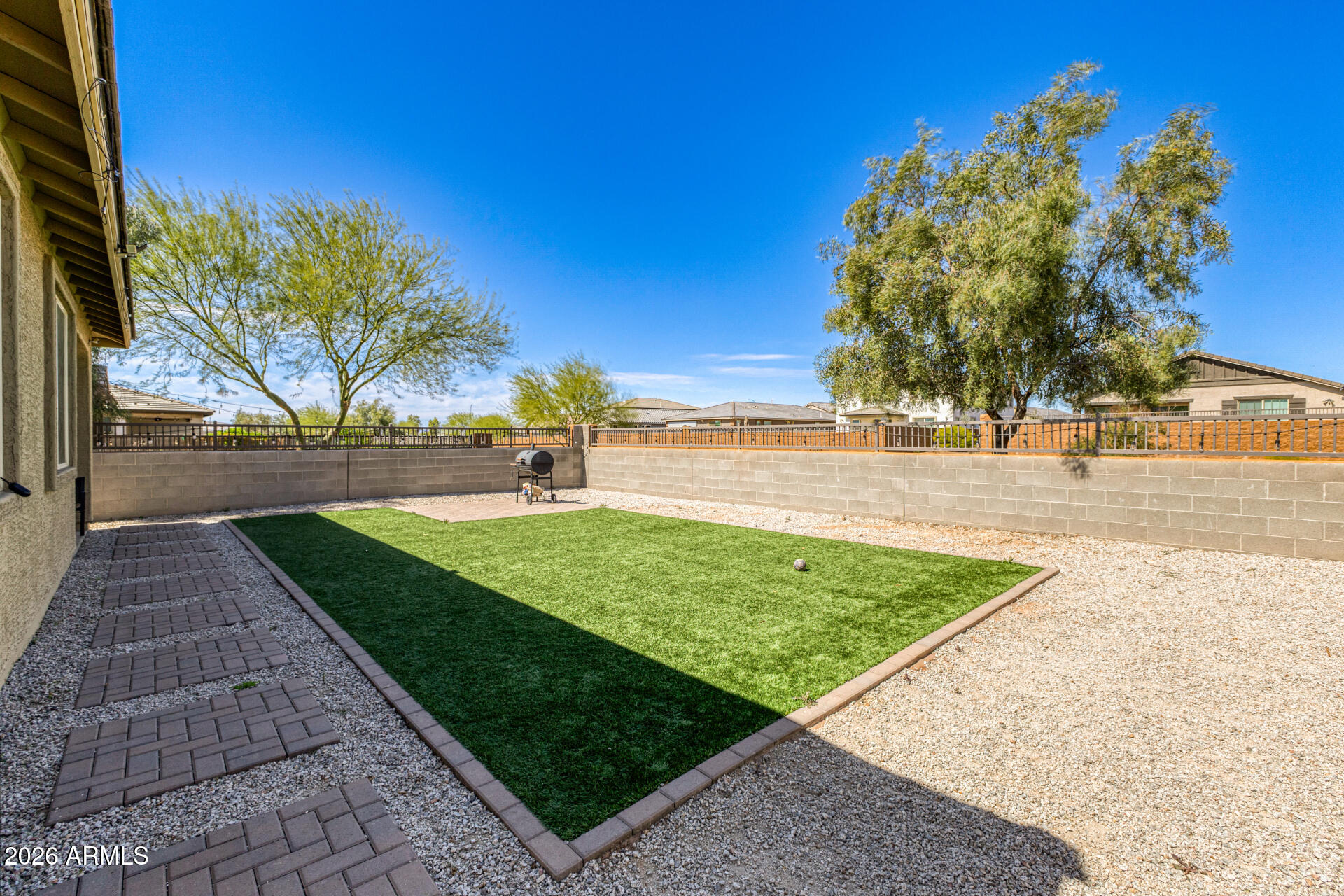Undisclosed Address Avondale, AZ 85323 - Photo 31 of 32 a view of a yard with flower plants and wooden fence