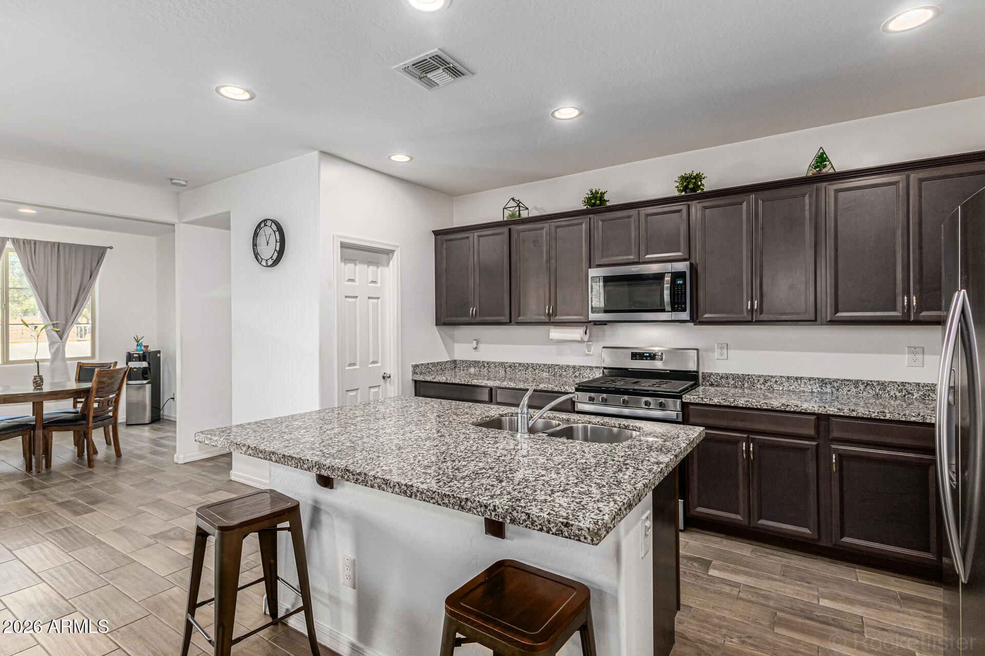Undisclosed Address Avondale, AZ 85323 - Photo 5 of 32 a kitchen with granite countertop kitchen island stainless steel appliances a stove sink microwave and cabinets