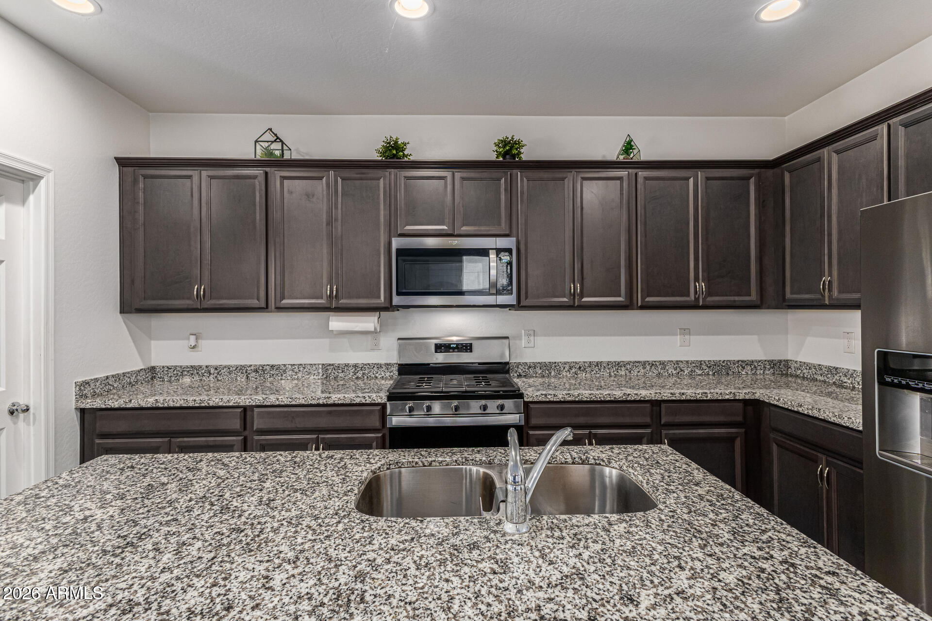 Undisclosed Address Avondale, AZ 85323 - Photo 6 of 32 a kitchen with a sink and a stove top oven with wooden floor