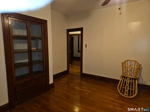 a view of a hallway with wooden floor and closet