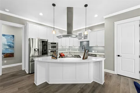 a kitchen with kitchen island a sink appliances and cabinets