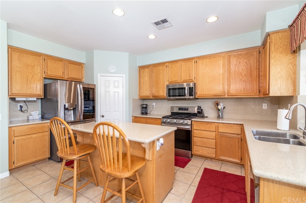 23746 Fieldcrest Lane Murrieta, CA 92562 - Photo 12 of 54 a kitchen with stainless steel appliances granite countertop a stove top oven a sink dishwasher and a refrigerator