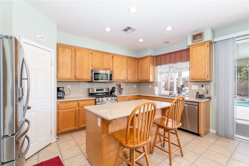 23746 Fieldcrest Lane Murrieta, CA 92562 - Photo 13 of 54 a kitchen with stainless steel appliances granite countertop a refrigerator a sink dishwasher a stove with white cabinets and wooden floor