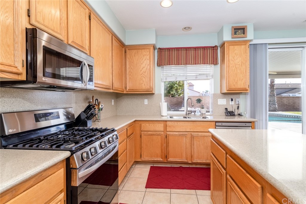 23746 Fieldcrest Lane Murrieta, CA 92562 - Photo 21 of 54 a kitchen with stainless steel appliances granite countertop a stove a sink and a microwave