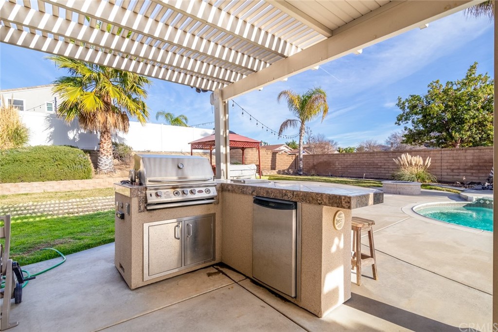 23746 Fieldcrest Lane Murrieta, CA 92562 - Photo 37 of 54 a kitchen view with stainless steel appliances granite countertop a barbecue grill and couches chair with garden view
