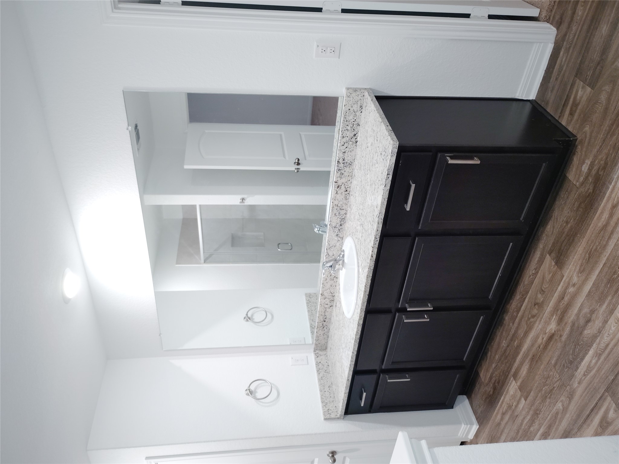 14024 Prairie Schooner Pass Elgin, TX 78621 - Photo 11 of 20 Bathroom featuring a dark wood-finish vanity with ample storage, a light speckled countertop, and a large integrated mirror