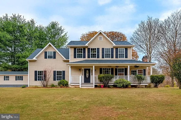 a front view of a house with yard and green space