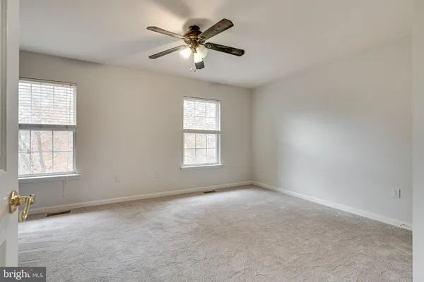 a view of an empty room with a ceiling fan