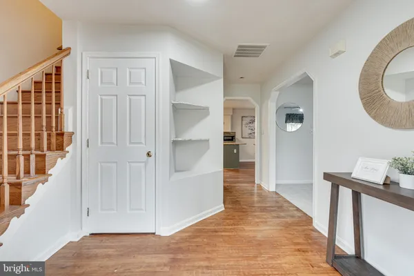 a view of a hallway with wooden floor and entryway