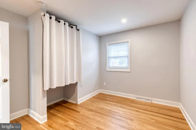 a view of a room with wooden floor and a window