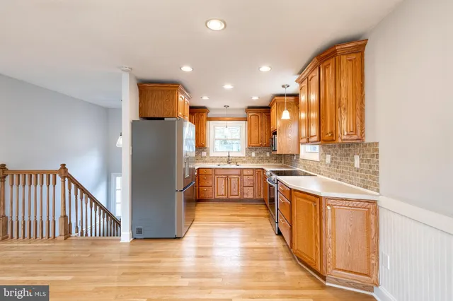 a kitchen with stainless steel appliances granite countertop a refrigerator a sink and a stove