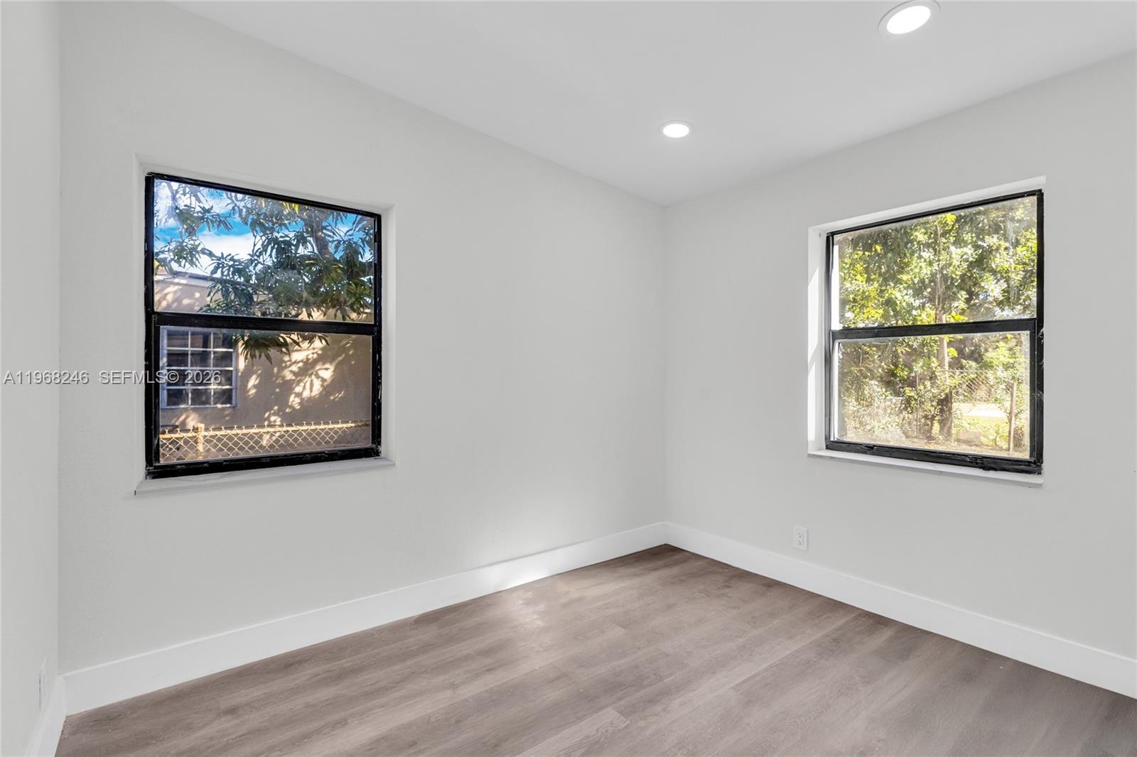 2330 Rutland Street Opa-Locka, FL 33054 - Photo 12 of 29 a view of an empty room with wooden floor and a window