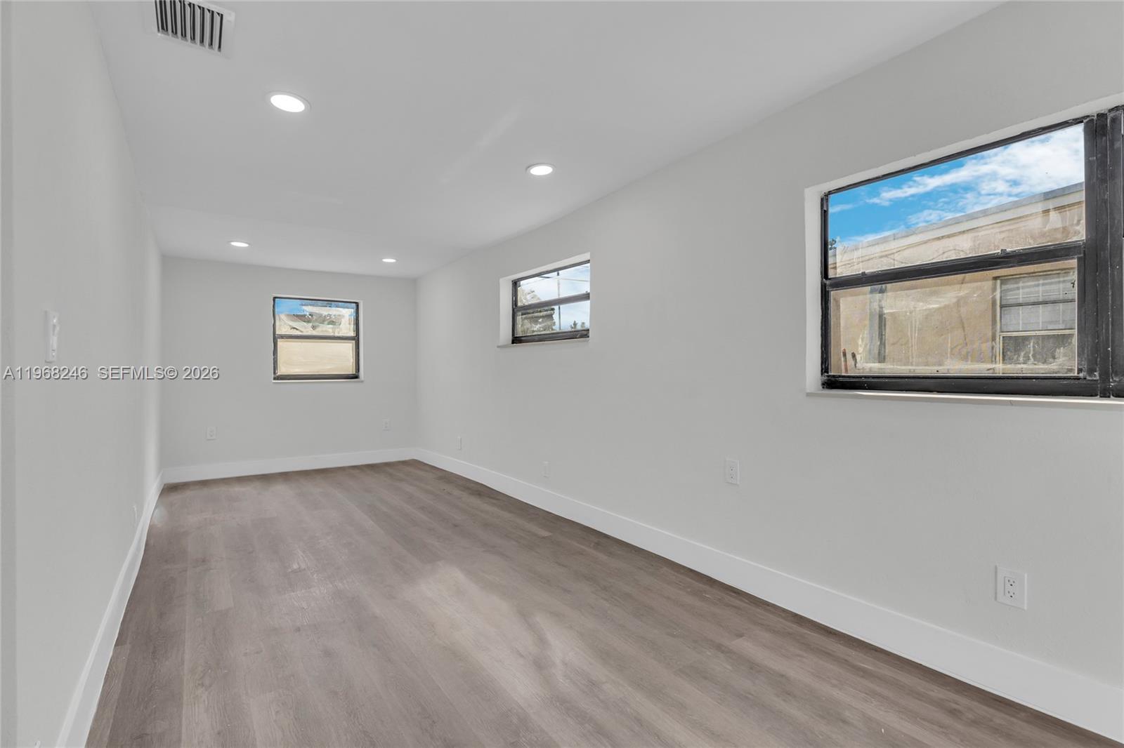 2330 Rutland Street Opa-Locka, FL 33054 - Photo 13 of 29 a view of an empty room with a window and wooden floor
