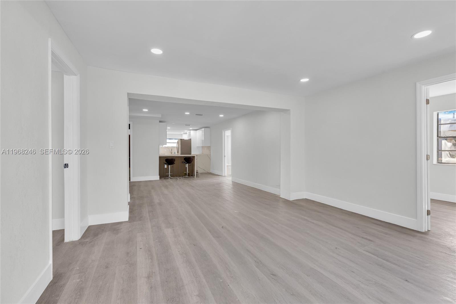 2330 Rutland Street Opa-Locka, FL 33054 - Photo 4 of 29 a view of an empty room with wooden floor kitchen view and a window