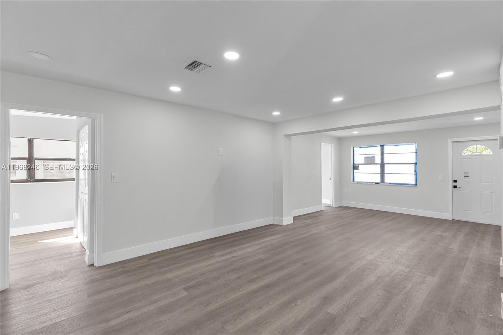 2330 Rutland Street Opa-Locka, FL 33054 - Photo 7 of 29 an empty room with wooden floor and windows