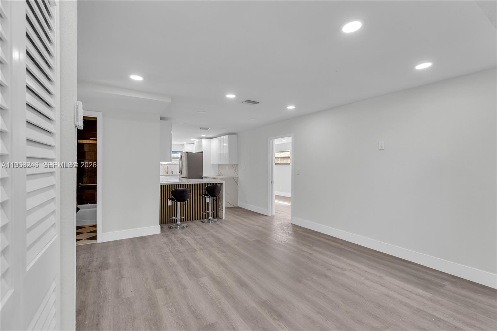 2330 Rutland Street Opa-Locka, FL 33054 - Photo 8 of 29 an empty room with wooden floor kitchen view and windows