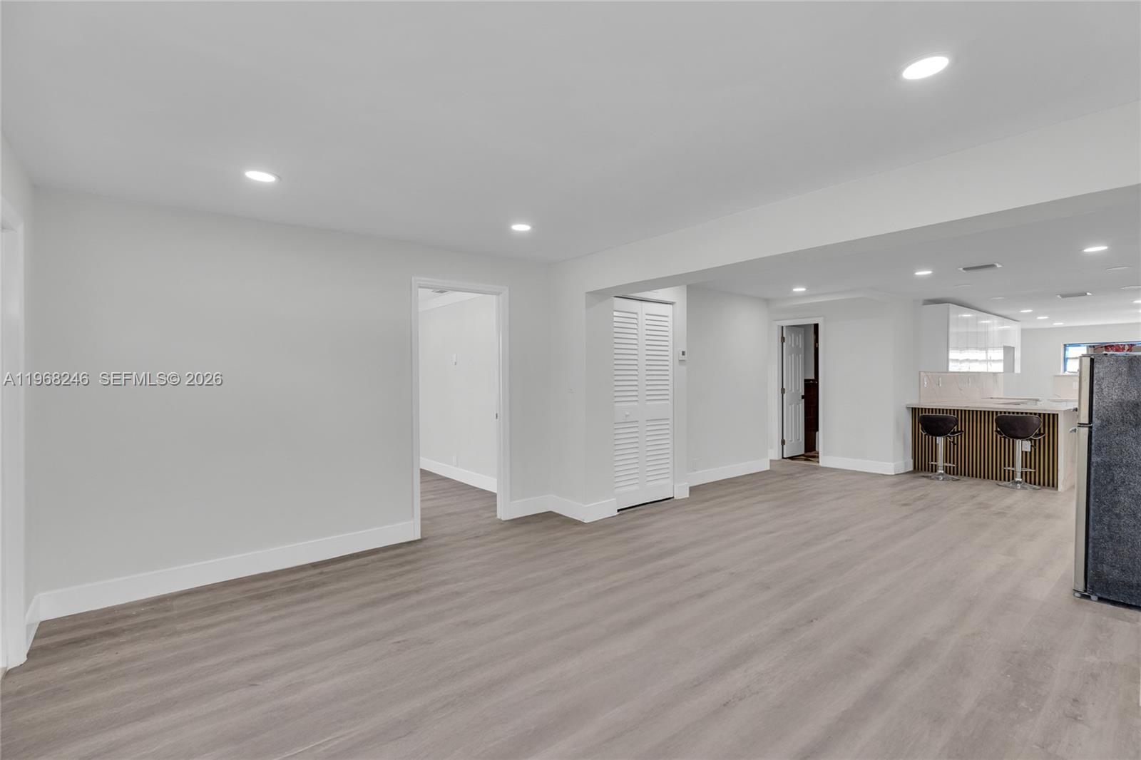 2330 Rutland Street Opa-Locka, FL 33054 - Photo 10 of 29 a view of an empty room with wooden floor and a kitchen