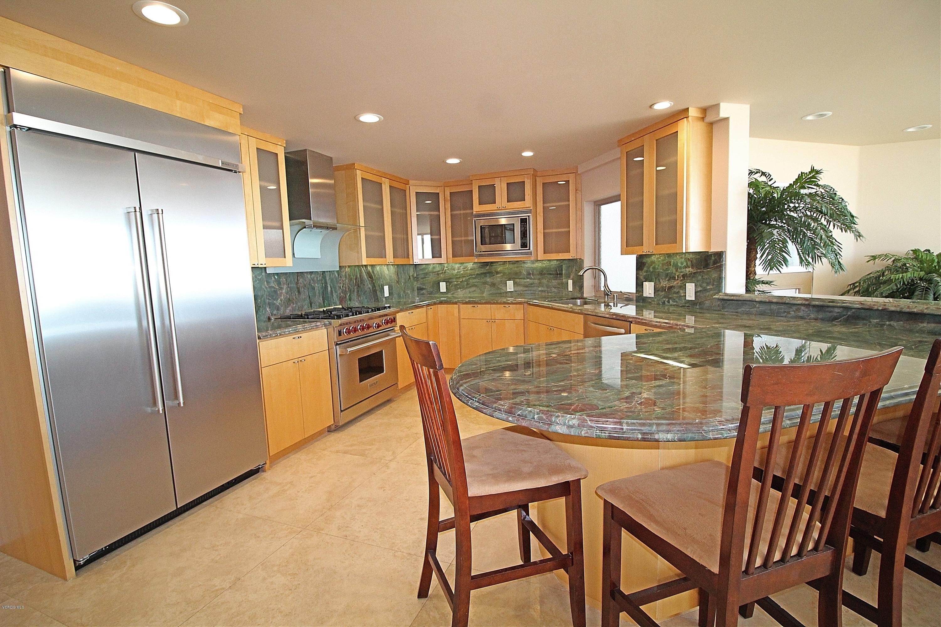 3629 Ocean Drive Oxnard, CA 93035 - Photo 25 of 60 a kitchen with stainless steel appliances granite countertop a table and chairs