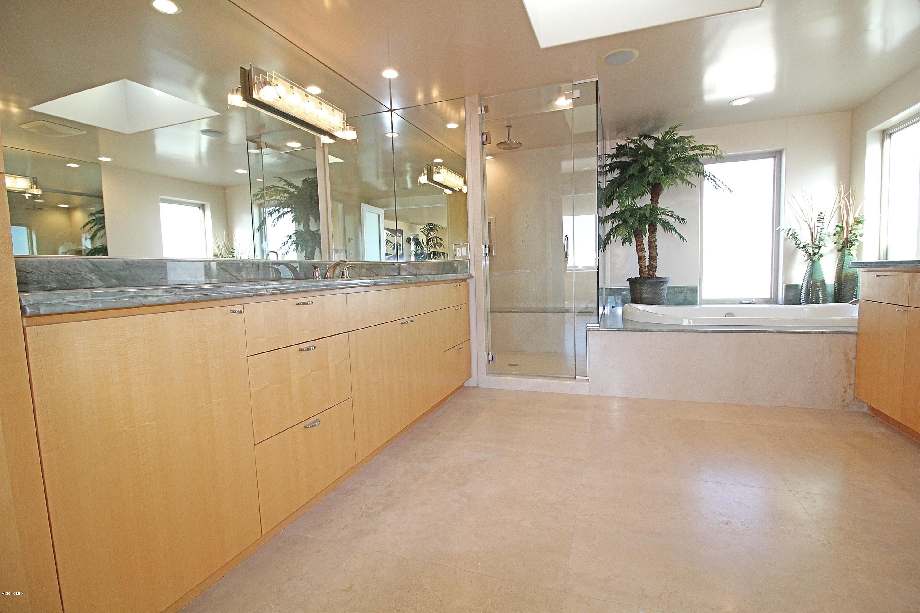 3629 Ocean Drive Oxnard, CA 93035 - Photo 35 of 60 a large white kitchen with granite countertop a sink and a large mirror