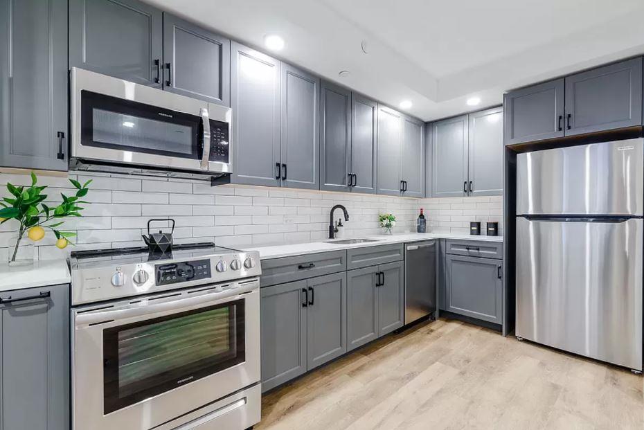 a kitchen with stainless steel appliances a stove microwave and sink
