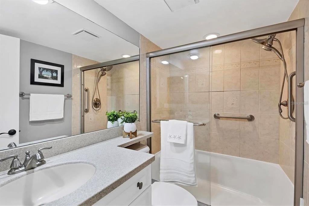 1640 Stickney Point Road, Unit 40101 Sarasota, FL 34231 - Photo 14 of 30 a bathroom with a granite countertop sink toilet and shower