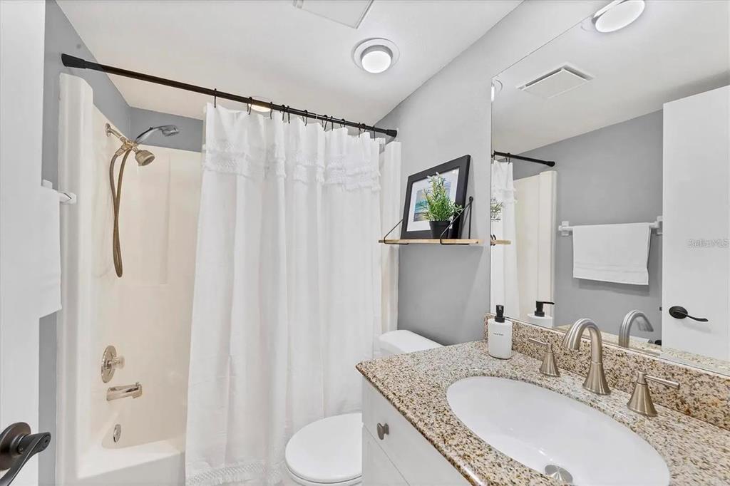 1640 Stickney Point Road, Unit 40101 Sarasota, FL 34231 - Photo 17 of 30 a bathroom with double vanity sink a mirror a bathtub and shower