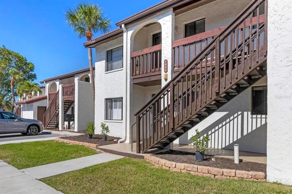 1640 Stickney Point Road, Unit 40101 Sarasota, FL 34231 - Photo 2 of 27 a view of a house with brick walls and a yard with plants