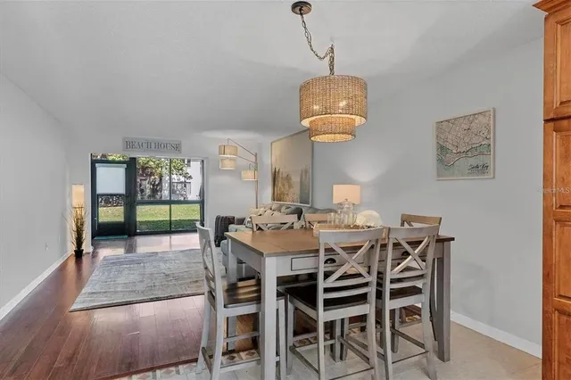 a view of a dining room and a livingroom with furniture wooden floor a chandelier
