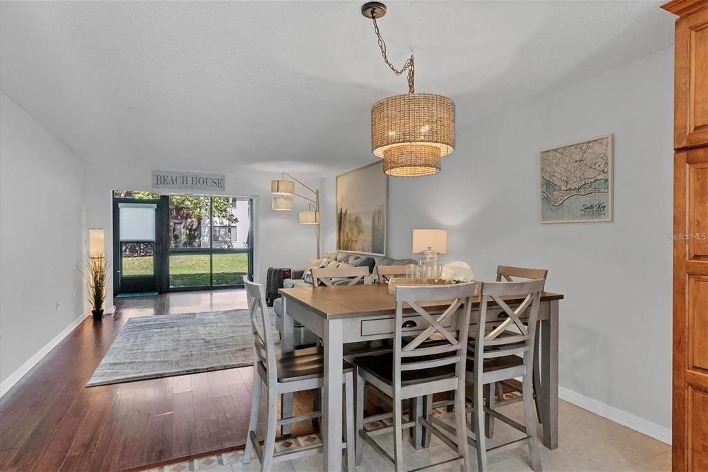 1640 Stickney Point Road, Unit 40101 Sarasota, FL 34231 - Photo 6 of 27 a view of a dining room and a livingroom with furniture wooden floor a chandelier