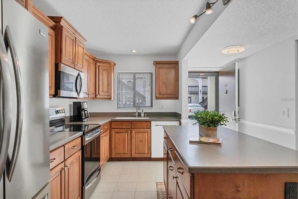 1640 Stickney Point Road, Unit 40101 Sarasota, FL 34231 - Photo 7 of 27 a kitchen with stainless steel appliances a sink a stove and a refrigerator