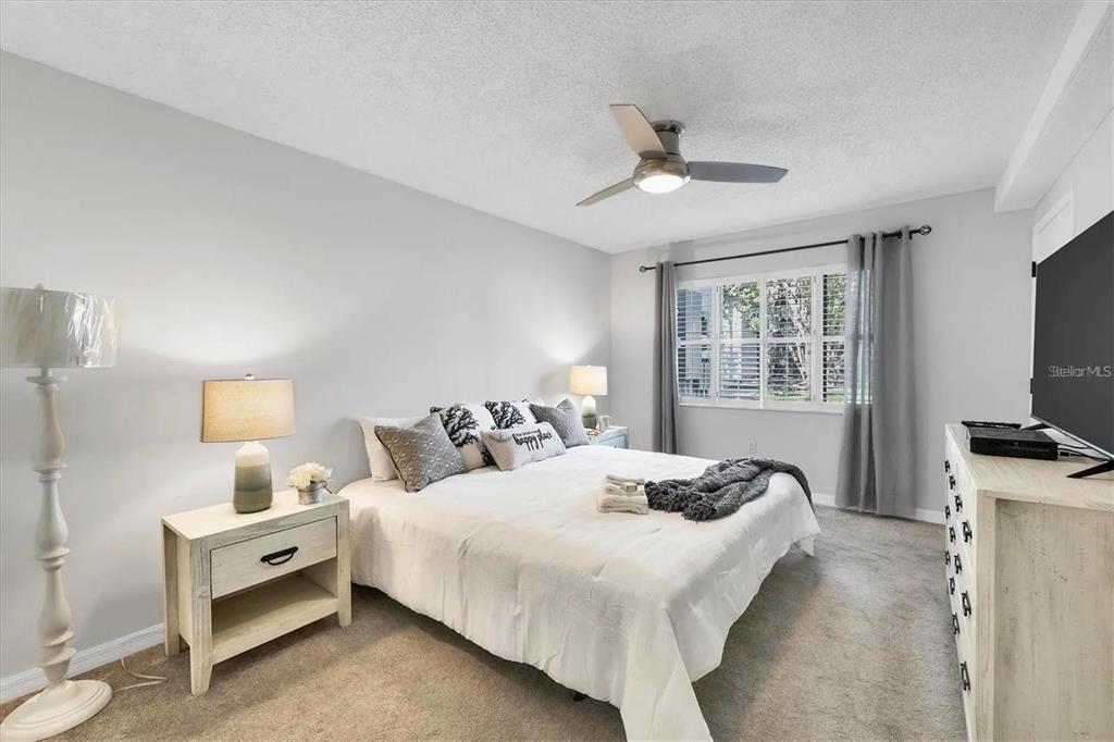 1640 Stickney Point Road, Unit 40101 Sarasota, FL 34231 - Photo 9 of 27 a bedroom with a bed and a flat tv screen on dresser