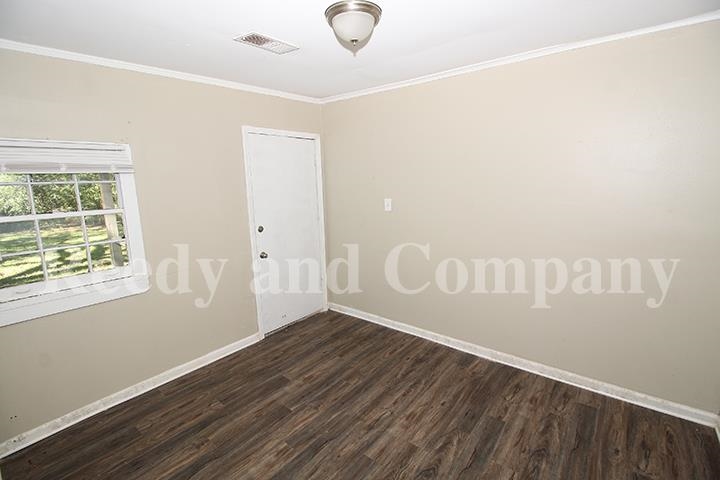 3947 McCain Road Memphis, TN 38109 - Photo 11 of 17 a view of an empty room with wooden floor and a window