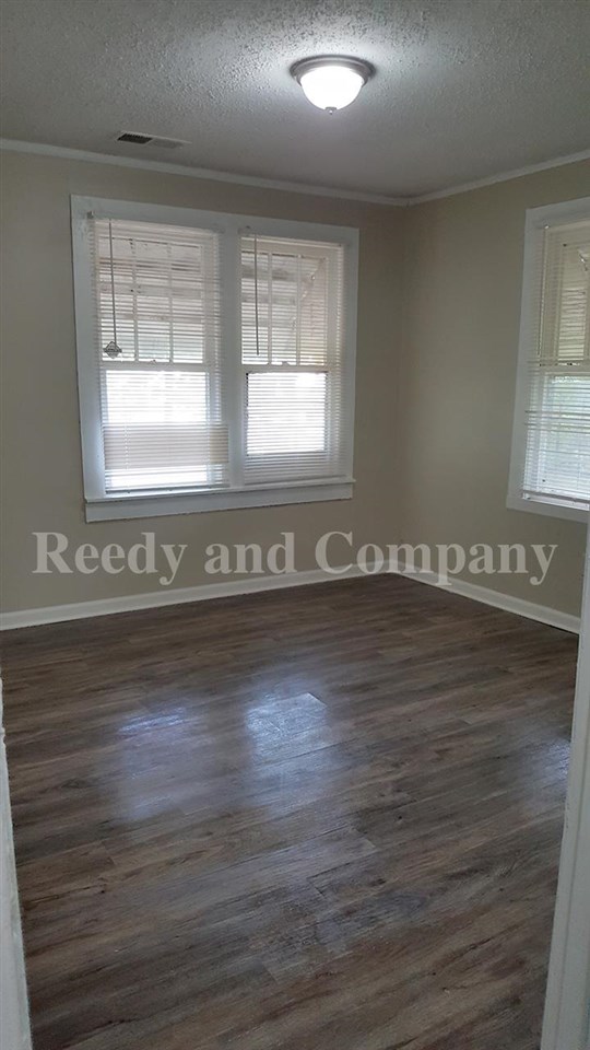 3947 McCain Road Memphis, TN 38109 - Photo 16 of 17 a view of an empty room with wooden floor and a window