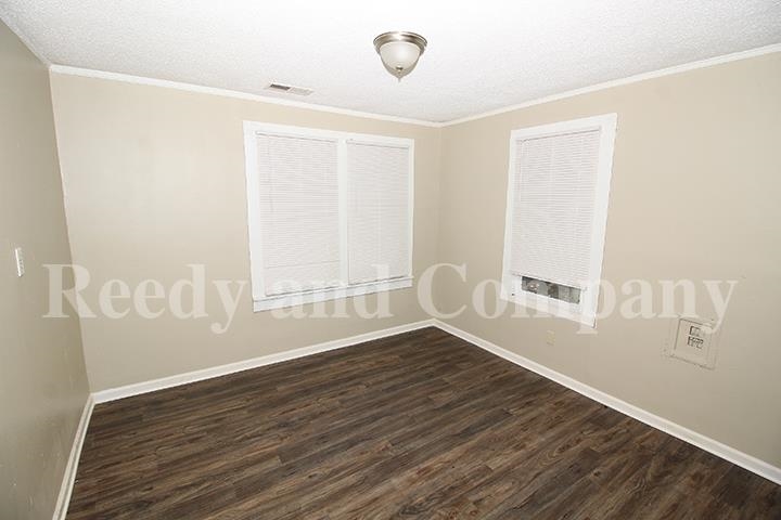 3947 McCain Road Memphis, TN 38109 - Photo 6 of 17 an empty room with wooden floor and windows