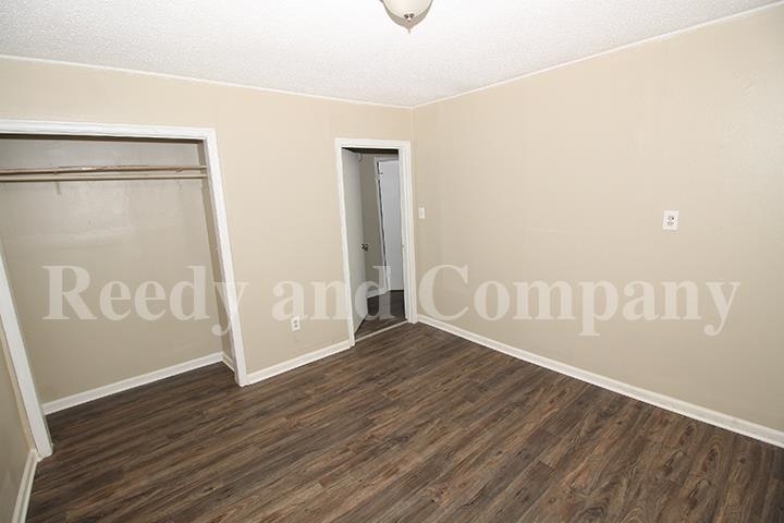 3947 McCain Road Memphis, TN 38109 - Photo 7 of 17 a view of an empty room with wooden floor and a window