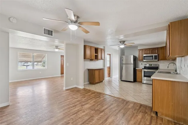 a view of a kitchen with a sink stove cabinets and entryway