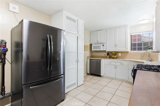 a kitchen with a refrigerator sink and cabinets