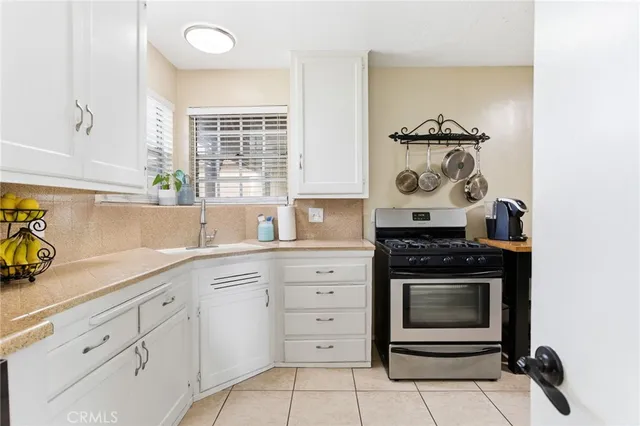 a kitchen with white cabinets and appliances