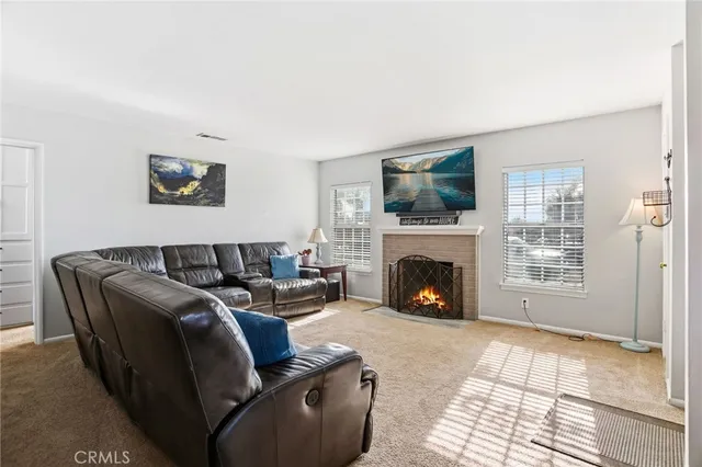 a living room with furniture a flat screen tv and a fireplace