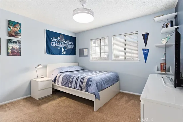 a spacious bedroom with a bed and a flat screen tv