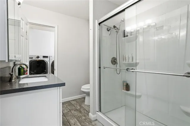 a bathroom with a granite countertop sink a toilet and shower