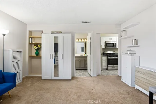 a view of a kitchen with refrigerator and an empty room