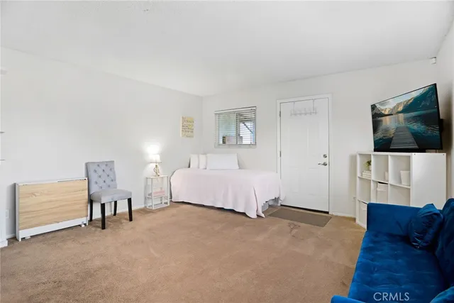 a spacious bedroom with a bed and a flat screen tv