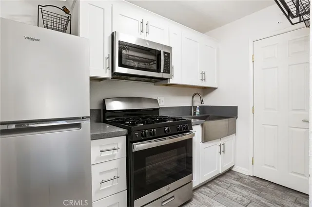 a kitchen with stainless steel appliances a stove a microwave and sink