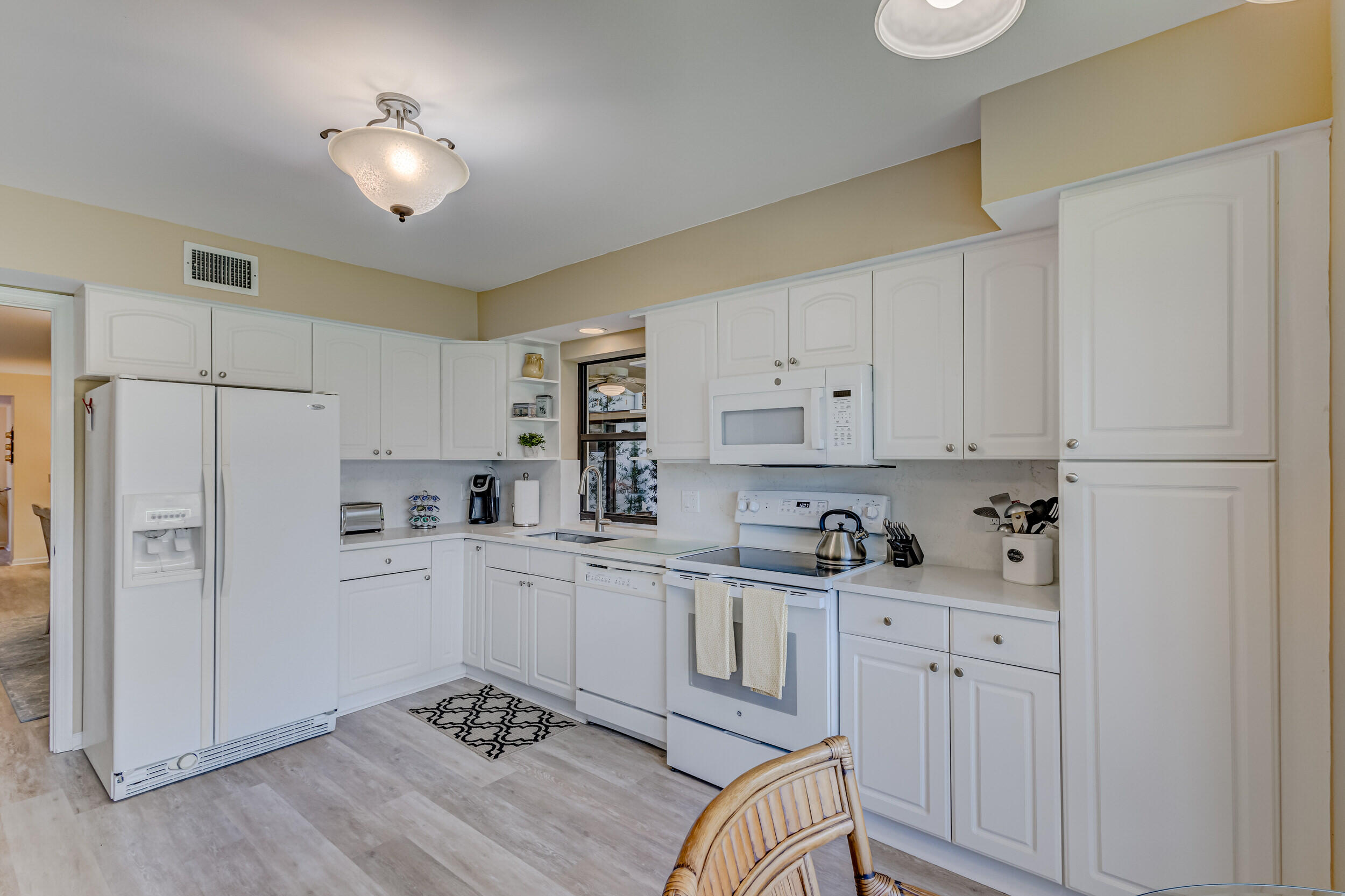 16623 Traders Crossing North, Unit 131 Jupiter, FL 33477 - Photo 15 of 42 a kitchen with white cabinets and stainless steel appliances
